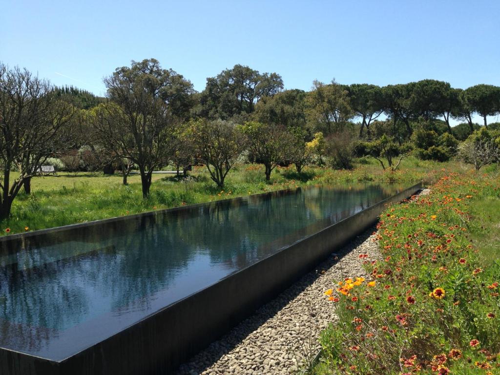 a drainage ditch with water in a field at Quinta Do Miguel in Aldeia do Meco