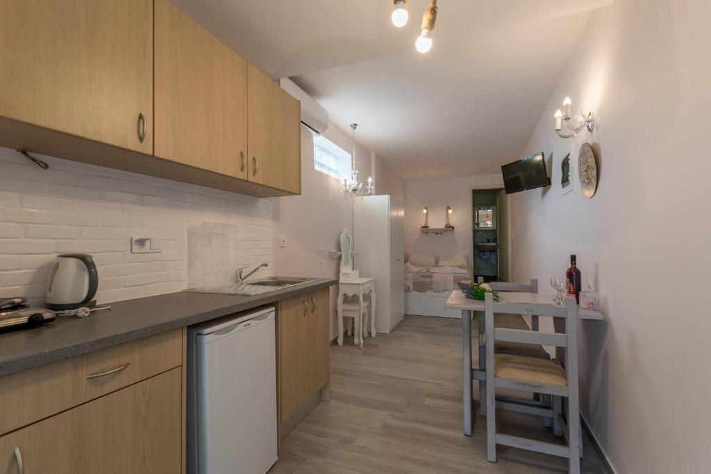 a kitchen with wooden cabinets and a table in it at Olympus Studios in Malia