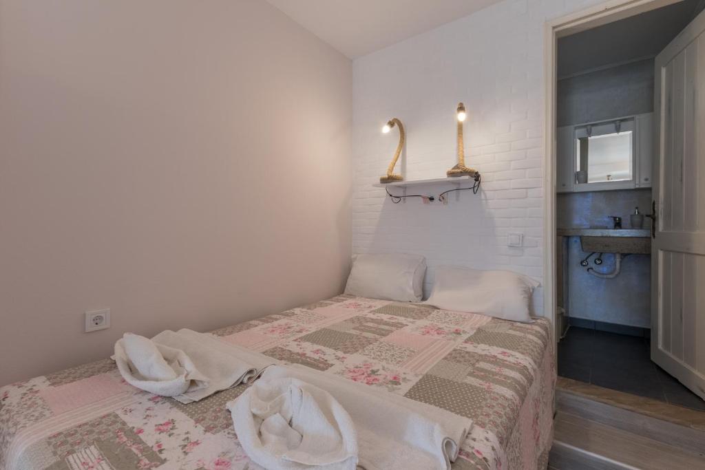 a small bedroom with a bed with a blanket at Olympus Studios in Malia