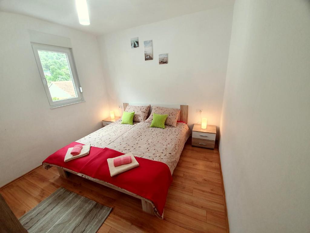a small bedroom with a bed and two lamps at Apartments Lara in Drvenik