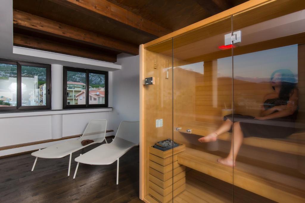 a woman sitting in a shower in a room at Hotel Cala Luna in Cala Gonone
