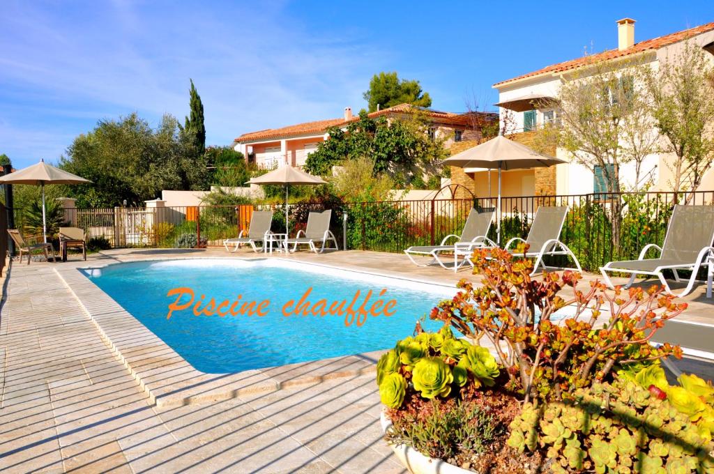 een zwembad in een tuin met stoelen en een huis bij Résidence Acqua è Terra 1 in Saint-Florent