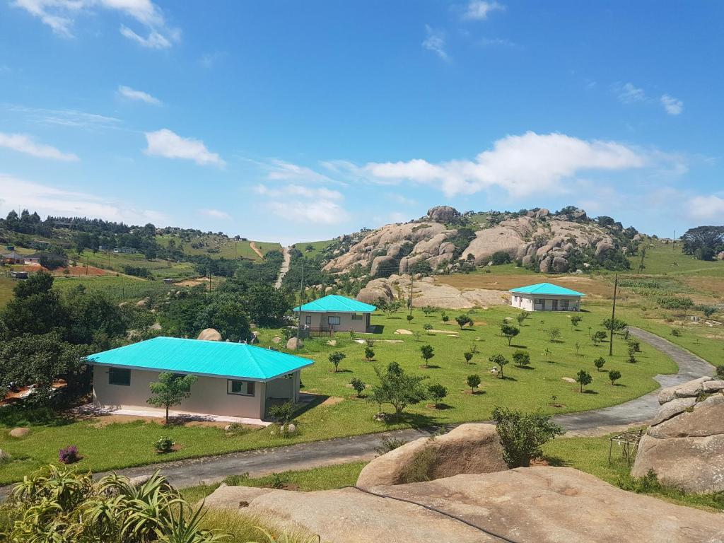 Mdzimba Mountain Lodge في إيزولويني: اطلالة جوية على مزرعة فيها بيوت على تلة