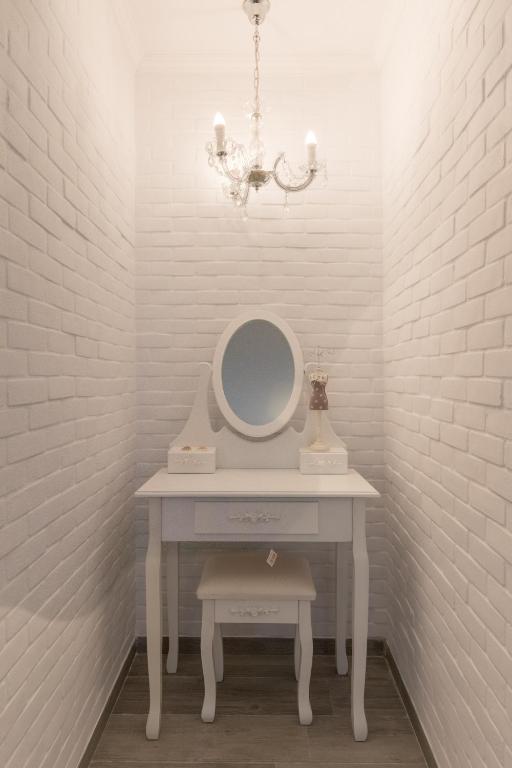 a white dressing table with a mirror and a chandelier at Olympus Studios in Malia