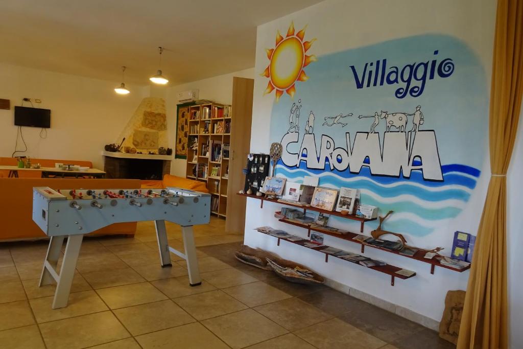 un negozio con un tavolo e un cartello che legge il villaggio Carna di B&B Casa per ferie VillaggioCarovana a Castiadas