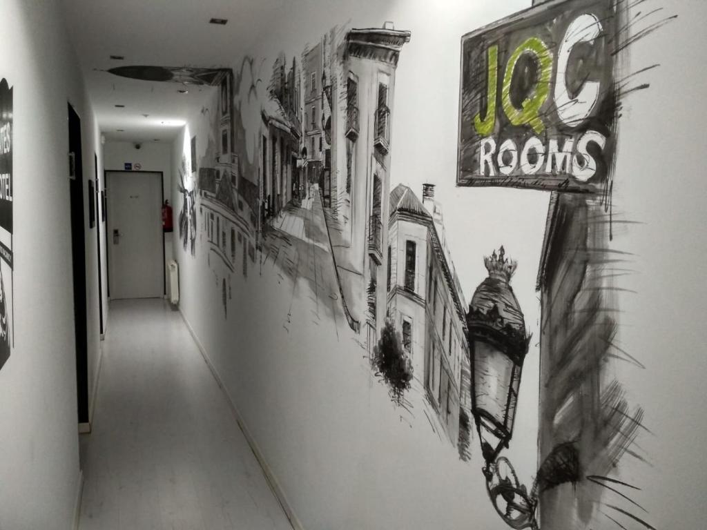 a hallway with drawings on the wall of a building at JQC Rooms in Madrid