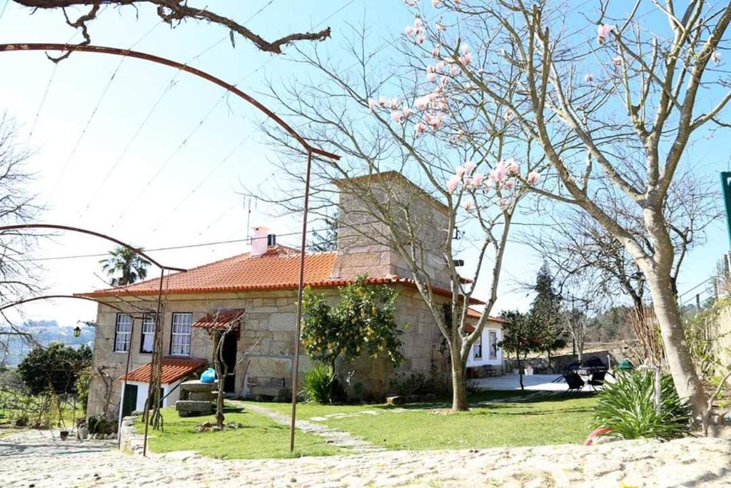 ein Haus mit einem Baum davor in der Unterkunft Quinta de Vila Verde- Paixão Ancestral, Turismo Rural in Marco de Canavezes