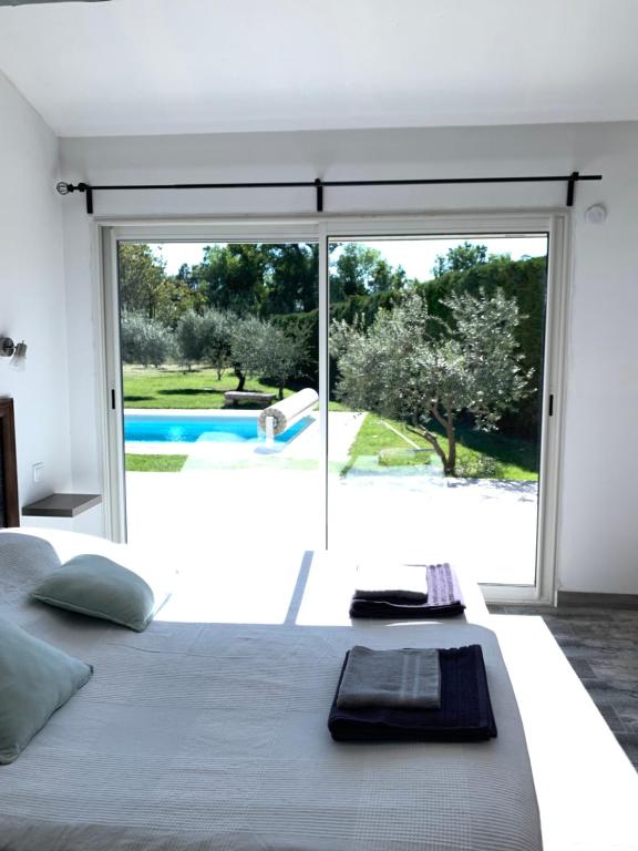 - une chambre avec un grand lit et une grande fenêtre dans l&#39;établissement Le Mazet Des Joncs en Provence, à Saint-Pierre-de-Vassols