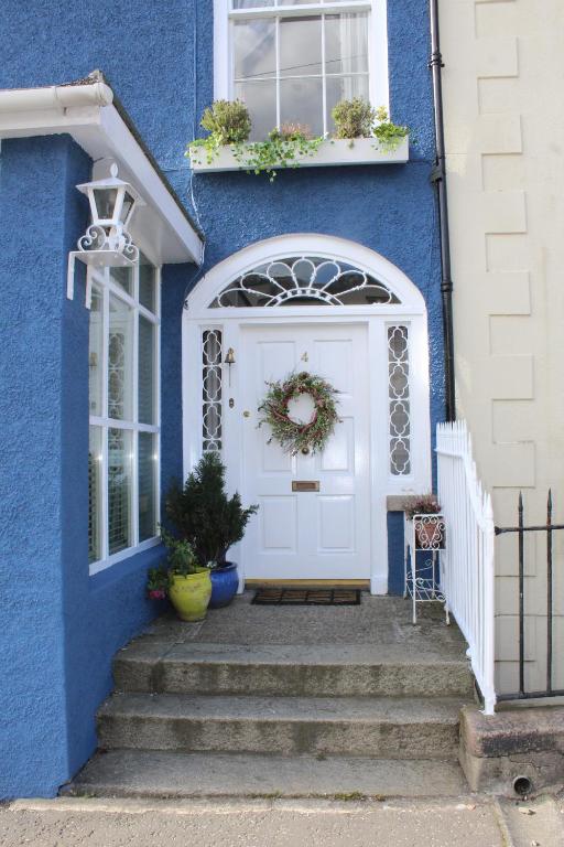 een blauw huis met een witte deur en een trap bij Hillside in Rostrevor