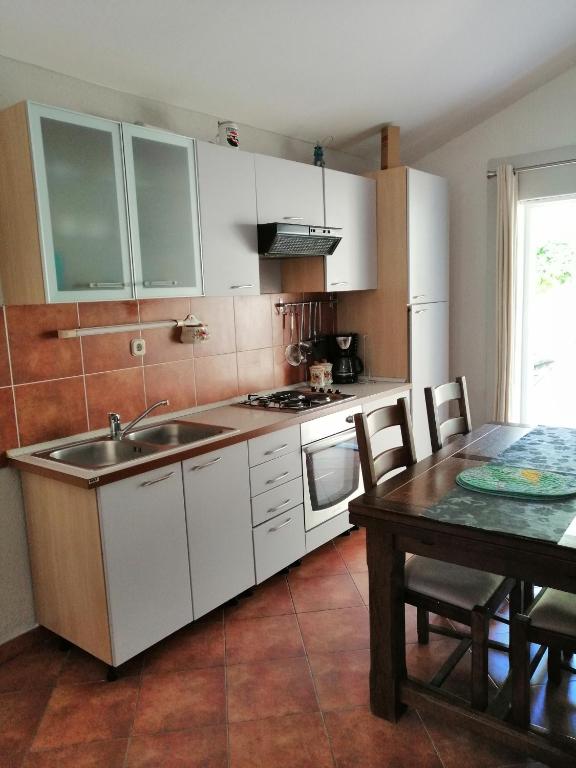 a kitchen with a sink and a table with a tableablish at Apartment Džoni in Split