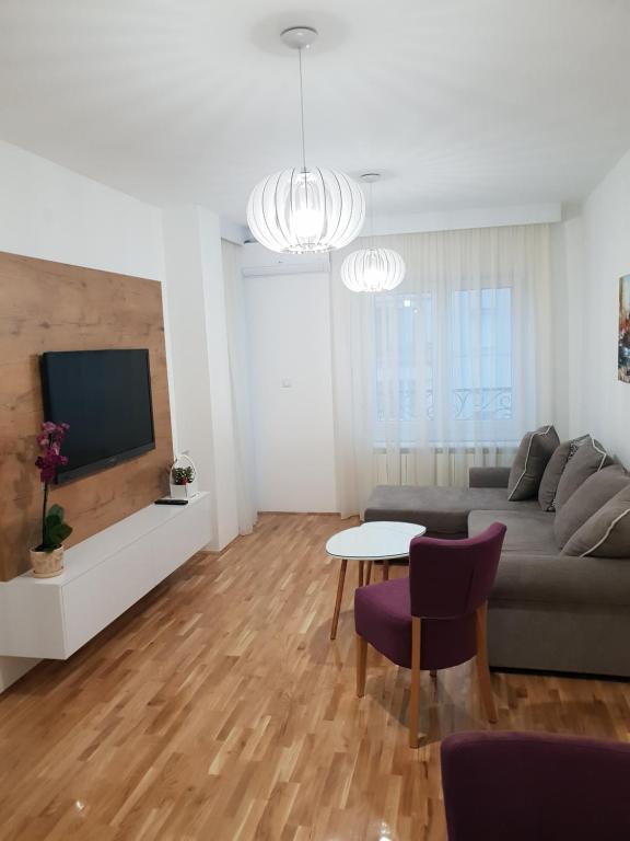 un soggiorno con divano e tavolo di Tvoj Apartman a Bijeljina