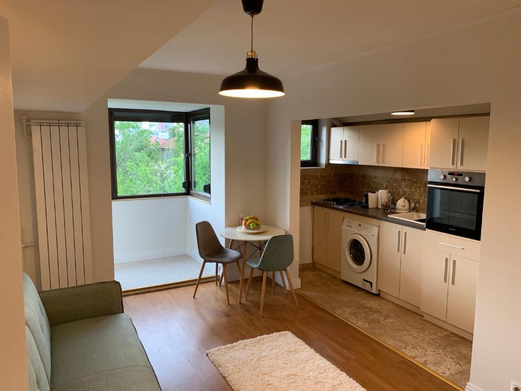 a kitchen with a table and chairs and a kitchen with a window at Floreasca Apartment Bach in Bucharest