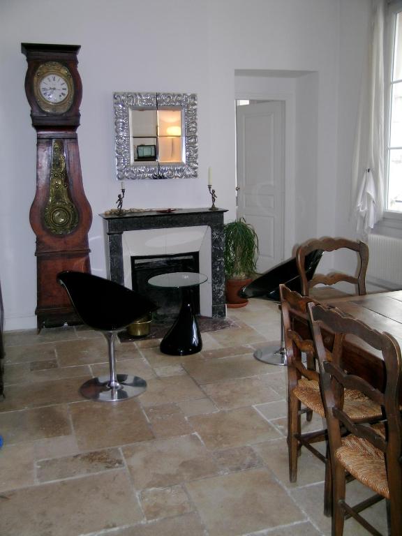 - un salon avec une table et une horloge grand-père dans l'établissement LE MARAIS 3 Bedrooms APT, à Paris