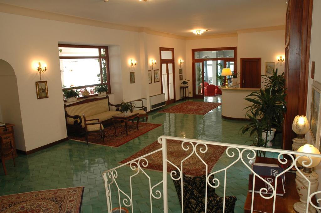 a lobby with a staircase and a living room at Hotel Belvedere in Conca dei Marini