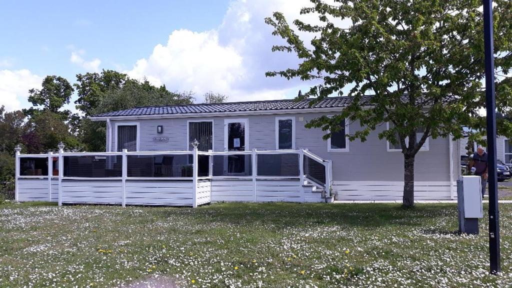 una casa blanca con una valla blanca delante de ella en Luxury 6 berth lodge at Quince 10 en Ferndown