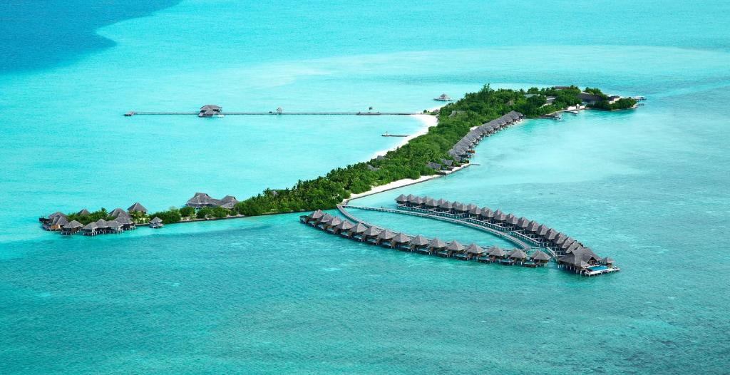 an island in the ocean with a dock in the water at Taj Exotica Resort & Spa in South Male Atoll