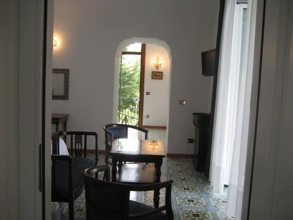 a room with a table and chairs and a hallway at Hotel Belvedere in Conca dei Marini