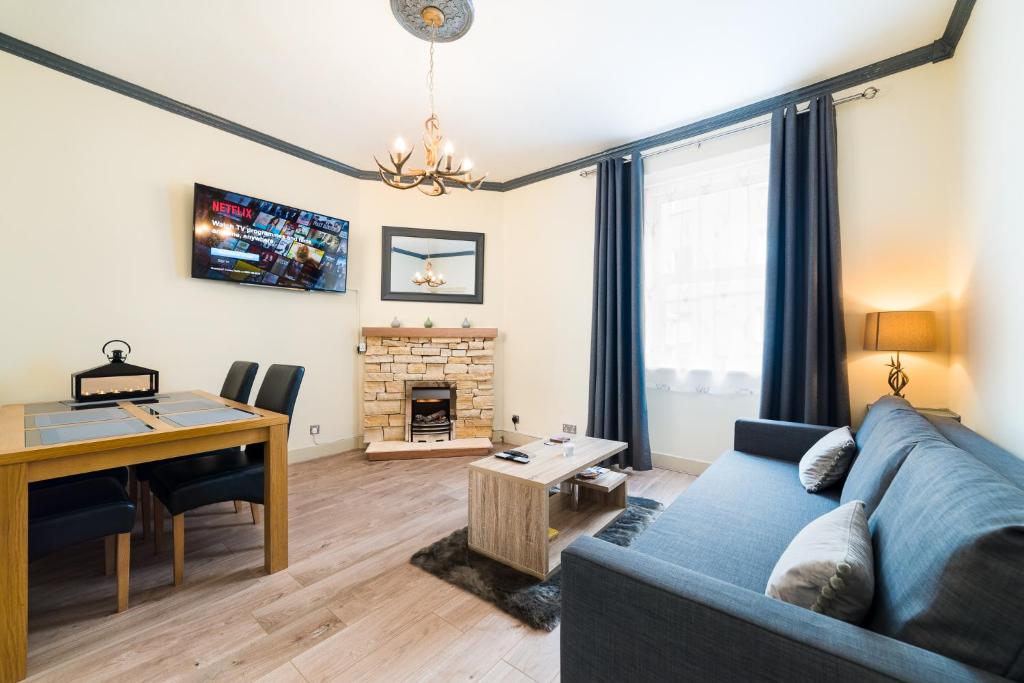 a living room with a blue couch and a desk at STAG City Centre apartment in Inverness