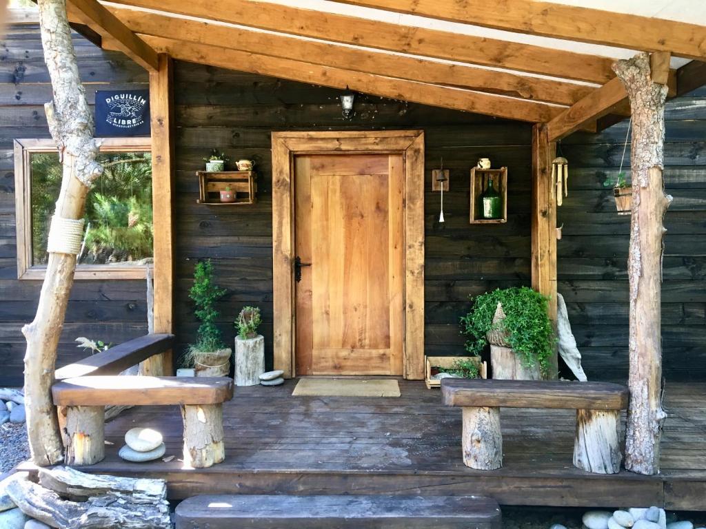 an entrance to a log cabin with a wooden door at Onai Hostel in Las Trancas