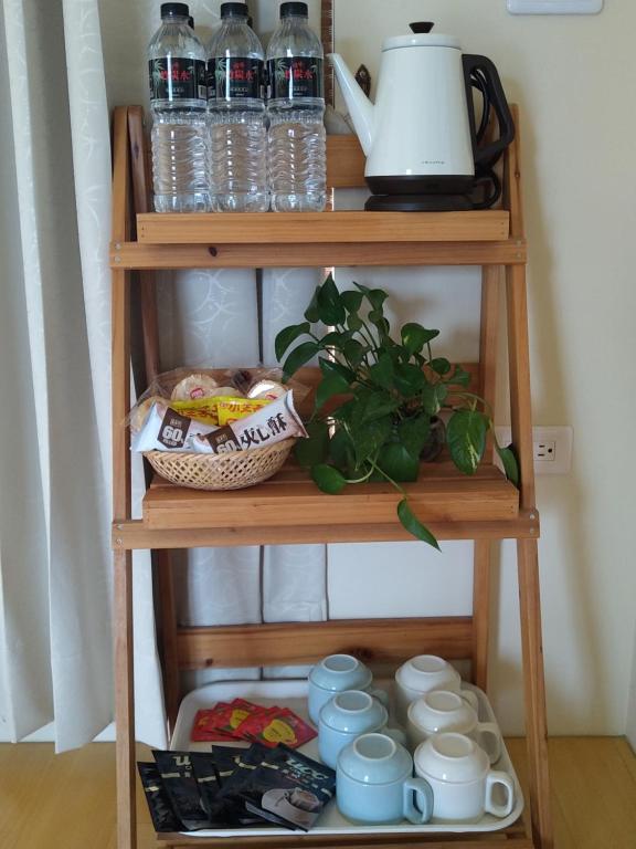 a wooden shelf with cups and a plant on it at Celine&#39;s B&amp;B in Fenglin