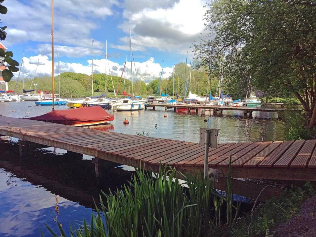 een houten steiger met boten in een jachthaven bij Pier 213 in Bad Zwischenahn