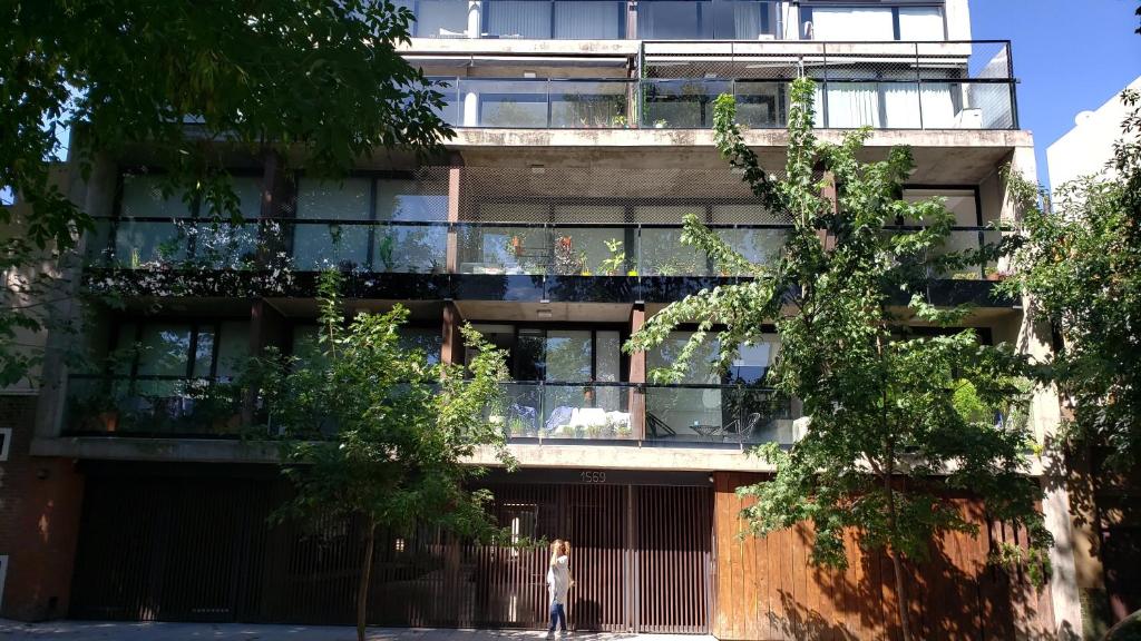 un condominio con balconi e una persona che cammina davanti di Soy Carlos, te espero en Palermo a Buenos Aires
