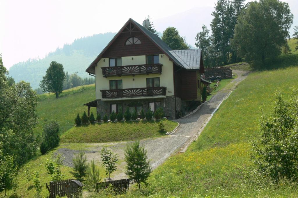 a house on top of a green hill at Rekreačný dom Chata Piero in Ždiar