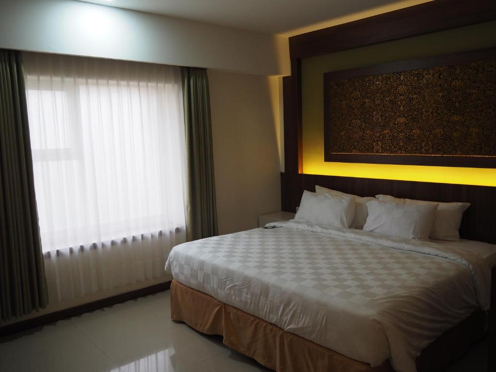 Postel nebo postele na pokoji v ubytování Luminor Hotel Banyuwangi By WH