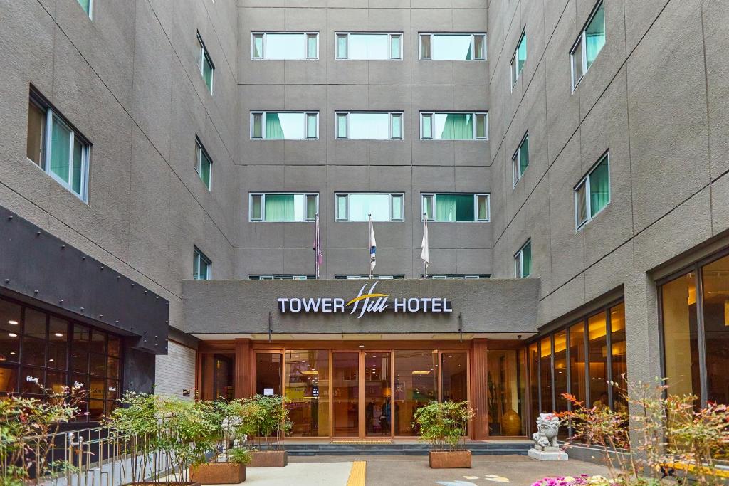 un edificio con un cartello che legge "Tower Inn Hotel" di Towerhill Hotel a Busan