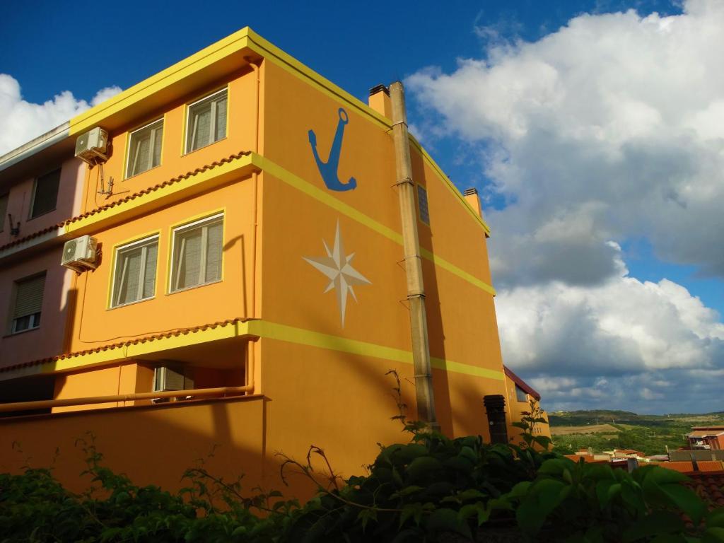ein gelbes Gebäude mit einem Schild an der Seite in der Unterkunft Appartamento La Collinetta in Gonnesa