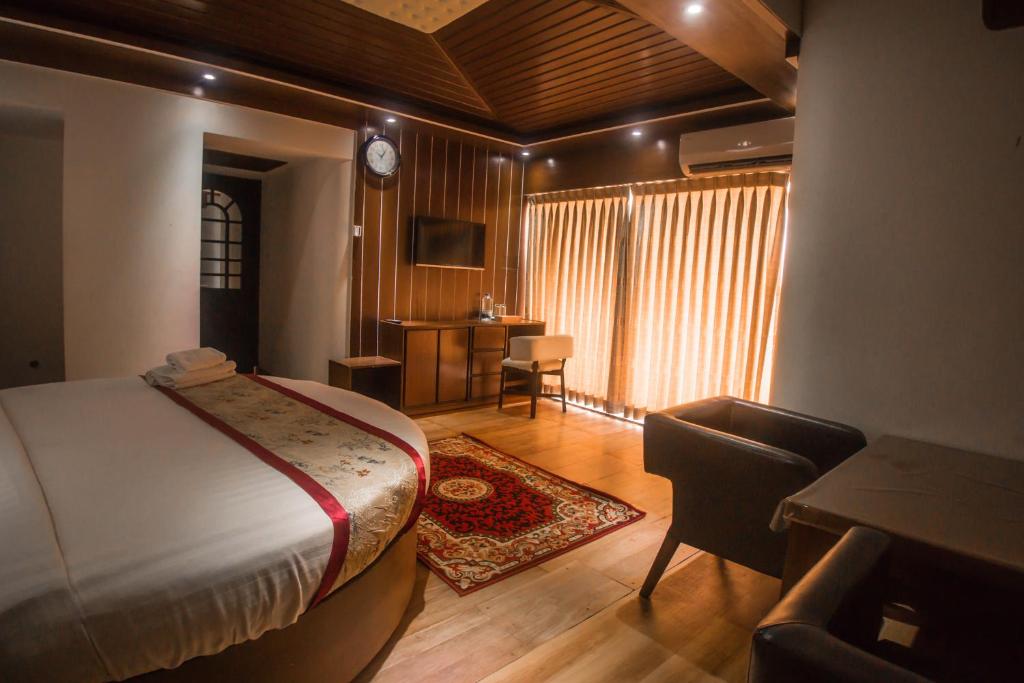 a bedroom with a bed and a desk and a chair at Prime Park Hotel in Cox's Bazar