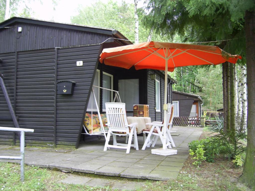 einen Tisch und zwei Stühle und einen Regenschirm auf einer Terrasse in der Unterkunft Ferienhaus Lilienstein in Bad Schandau