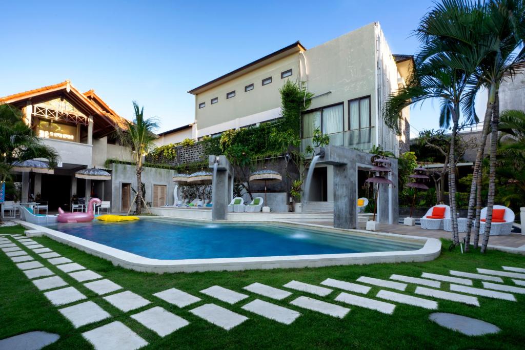 a swimming pool in front of a building at 18 Suite Villa Loft at Kuta in Kuta