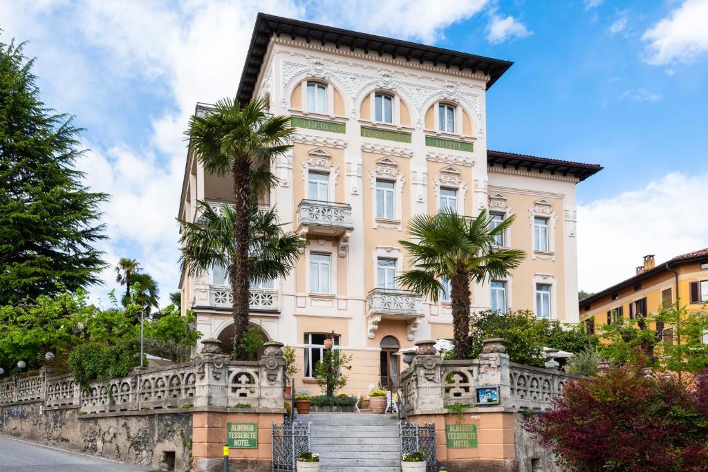 un edificio con palme di fronte di Albergo Hotel Tesserete a Tesserete