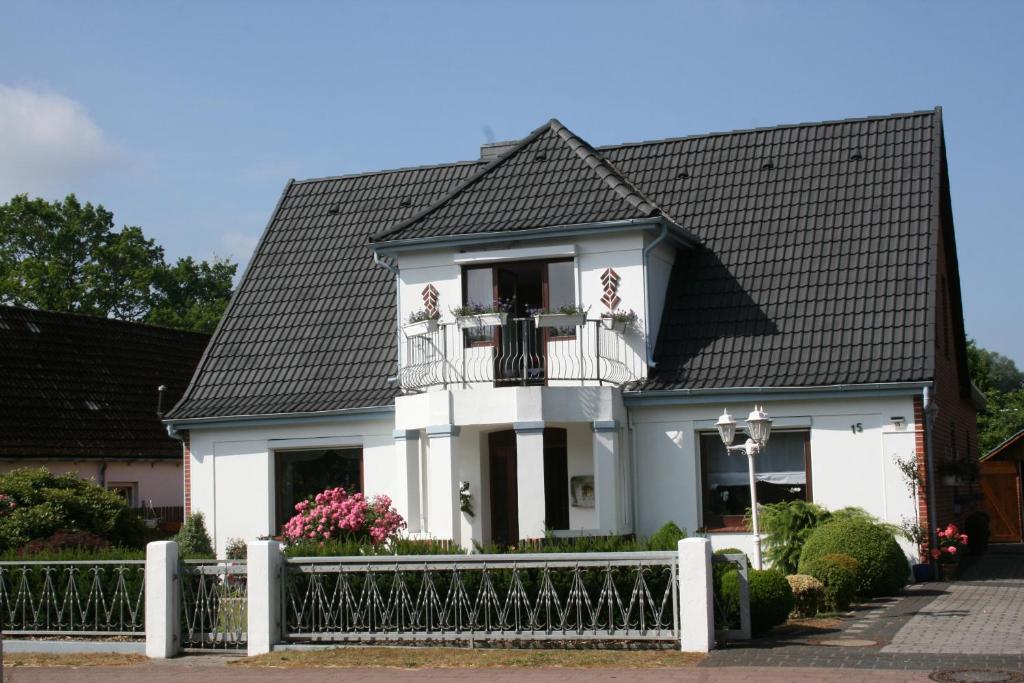 uma casa branca com um telhado preto em Fewo Hackländer em Hemmoor