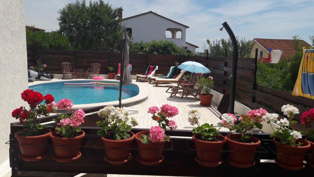 um pátio com vasos de flores e uma piscina em Villa Betiga em Mednjan