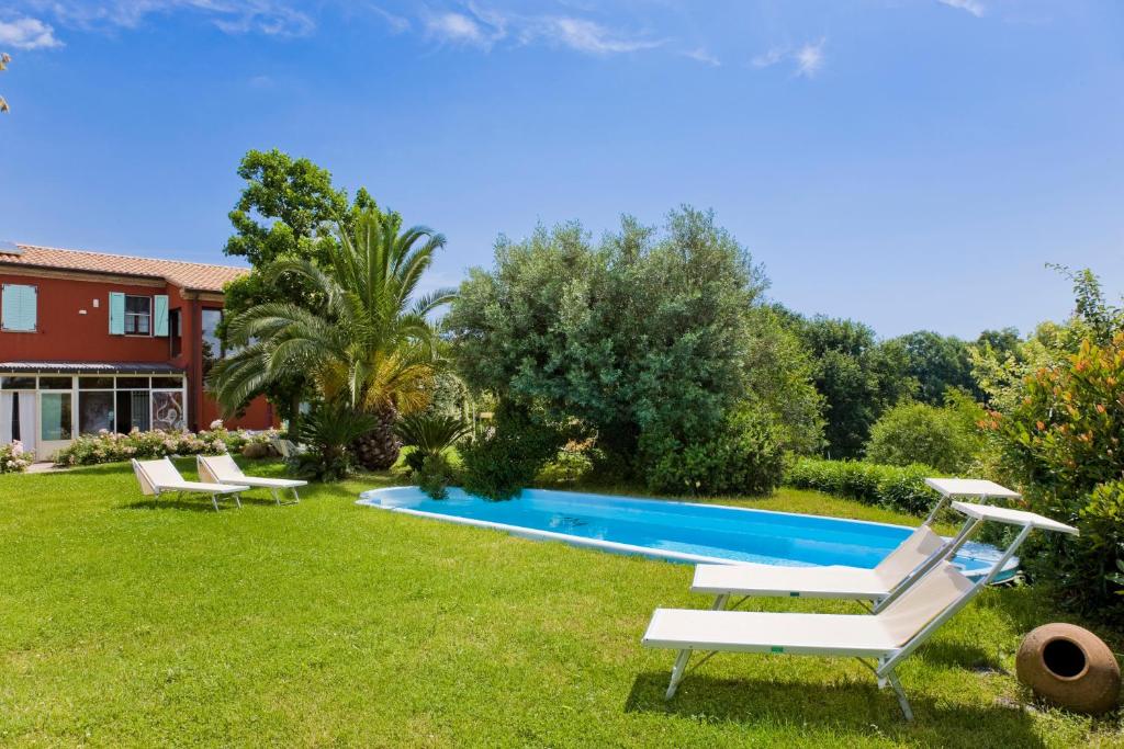 einen Pool in einem Garten mit zwei Liegestühlen in der Unterkunft Borgo Rosso Country House B&B in Sirolo