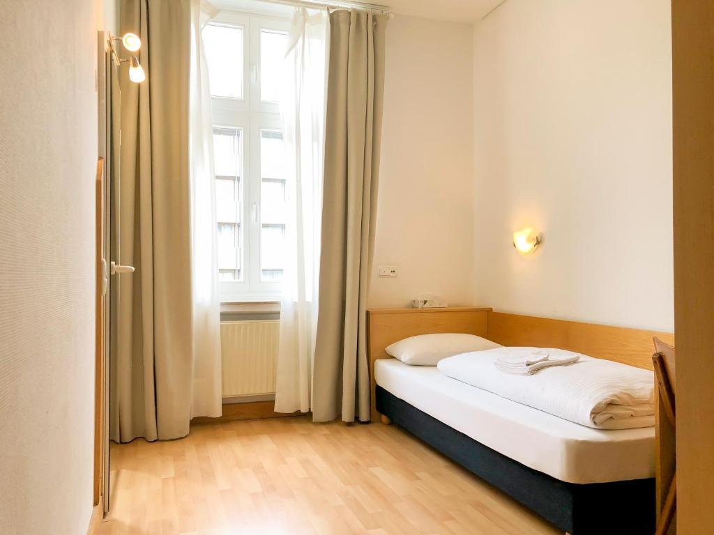 Bett in einem Zimmer mit einem großen Fenster in der Unterkunft Hotel Moon in Düsseldorf