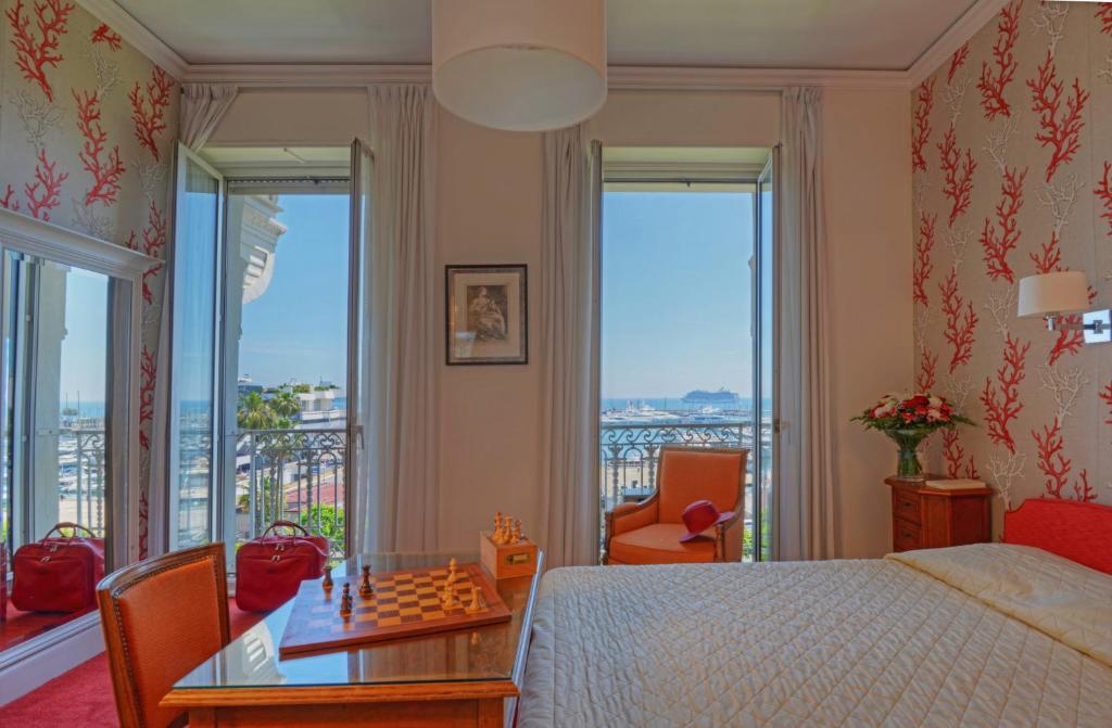 a bedroom with a bed and a chess board on a table at Hotel Splendid in Cannes