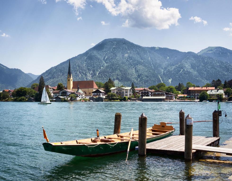 een boot op het water naast een dok bij Haus Kaiser in Rottach-Egern