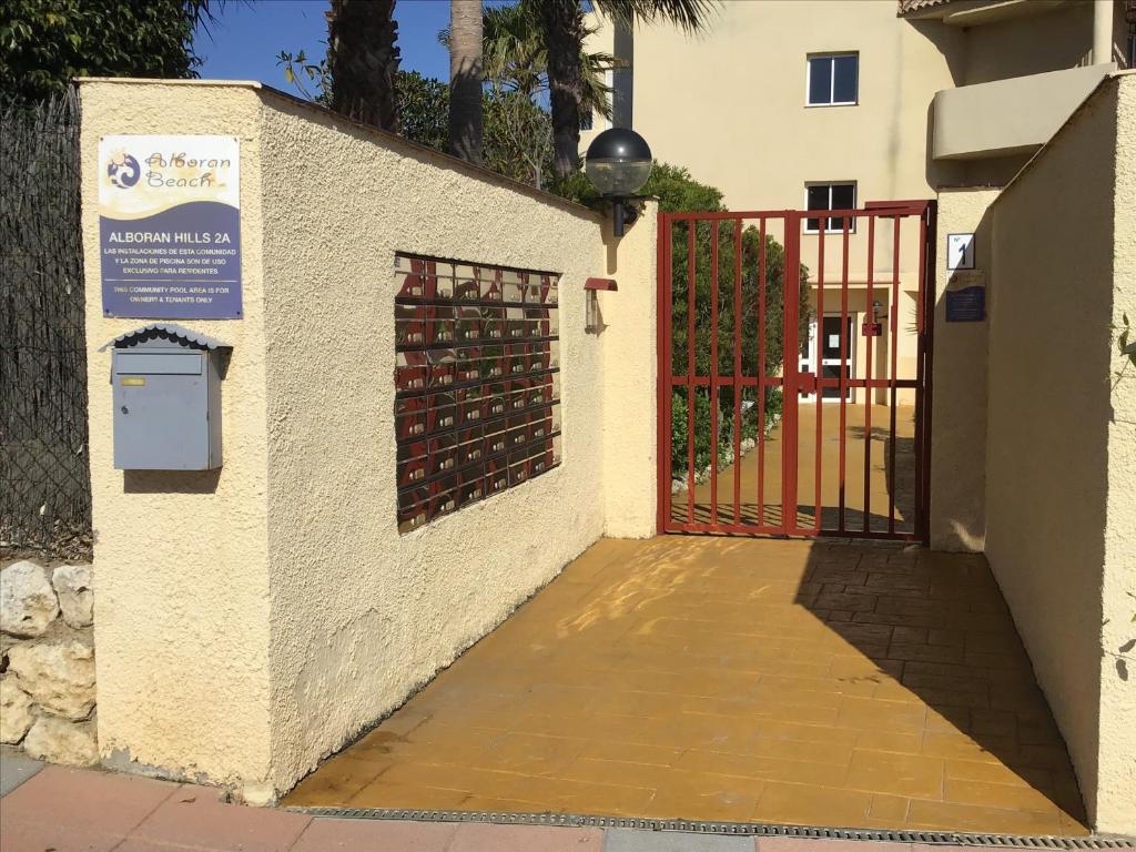 um portão para um edifício com um monte de garrafas de vinho em Alboran Hills Holiday Appartment em Manilva