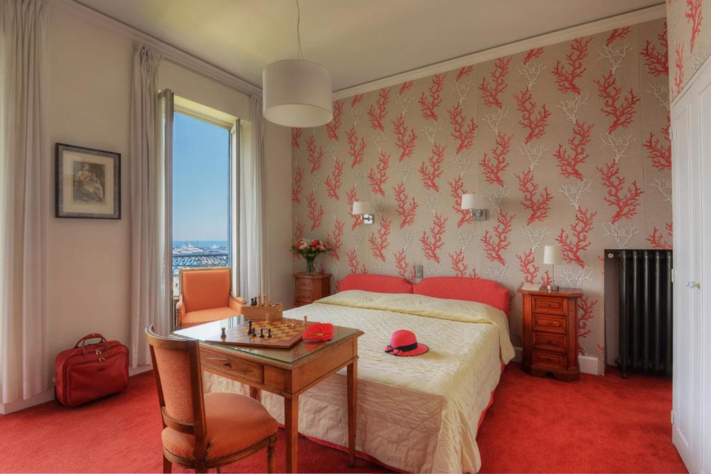 a bedroom with a bed and a table and a table sidx sidx sidx at Hotel Splendid in Cannes
