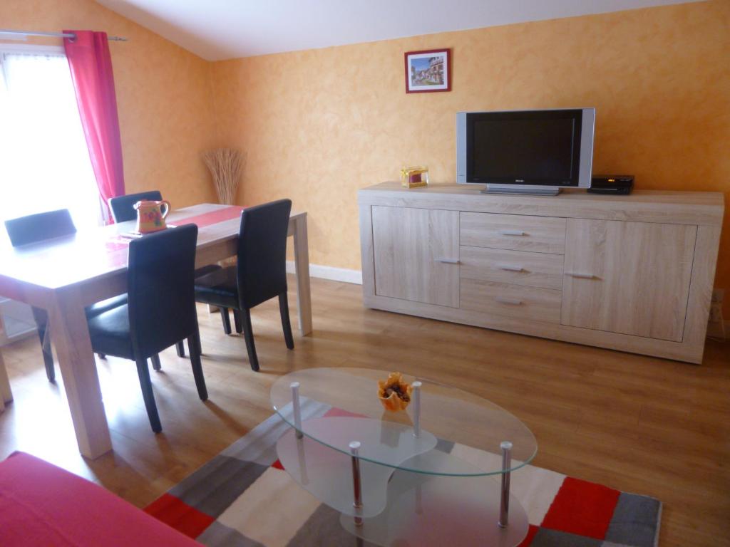 a living room with a dining table and a television at Appartement au coeur du pays basque : vue superbe in Saint-Esteben