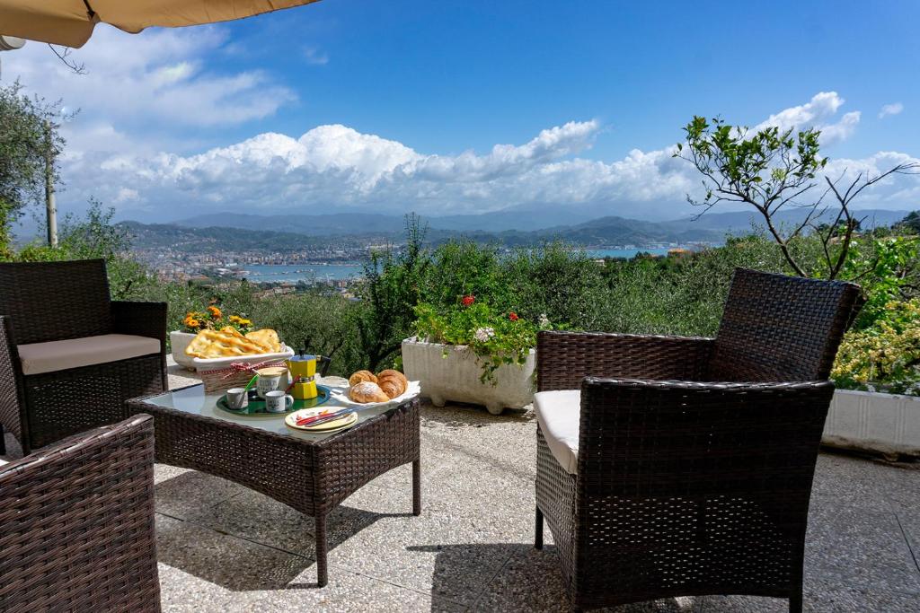 un patio con due sedie e un tavolo con cibo sopra di Gli ulivi sul Golfo e le 5 terre a La Spezia