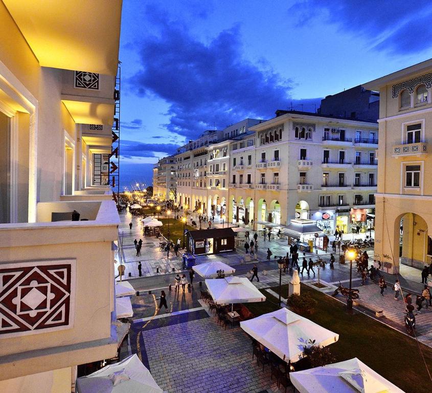 vista su una strada in una città di notte di Roomore Apartments a Salonicco