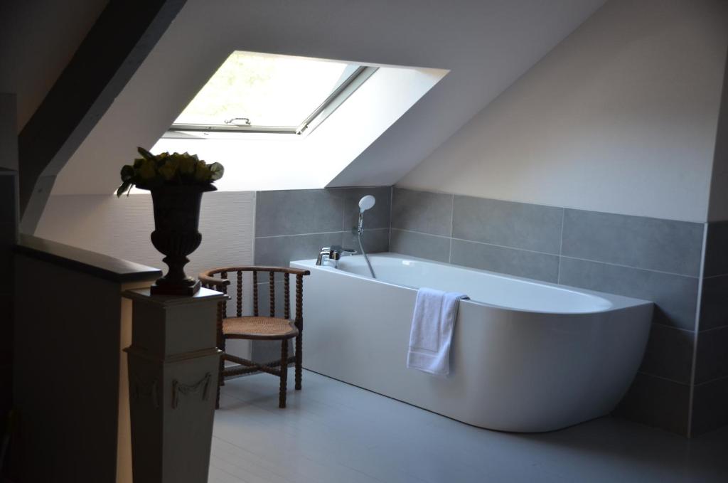 a bathroom with a large tub and a skylight at Domaine Utah Beach - Le Grand Hard in Sainte-Marie-du-Mont