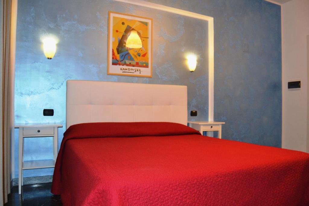 - une chambre avec un lit rouge et 2 tables dans l'établissement Diana Inn Accommodations, à Pompéi