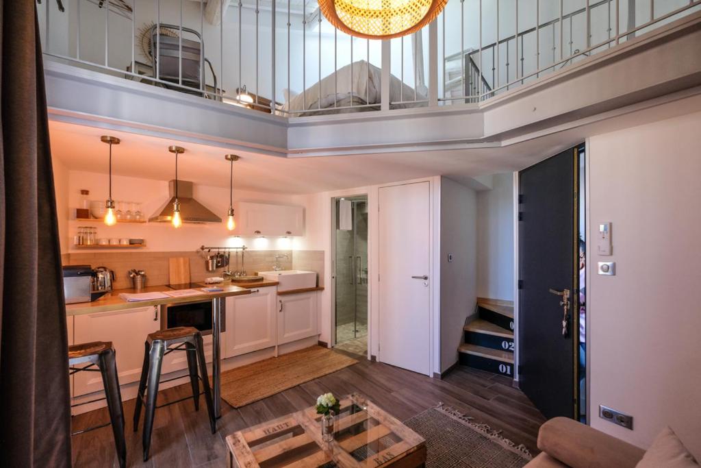 a kitchen and living room with a balcony at Demeure Terrisse Les Studios in Marseillan