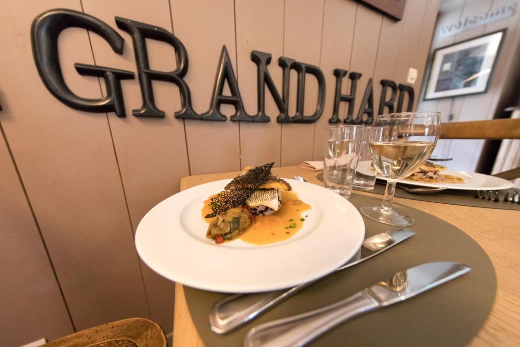 a plate of food on a table with wine glasses at Domaine Utah Beach - Le Grand Hard in Sainte-Marie-du-Mont