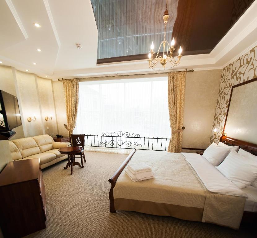 um quarto de hotel com uma cama e um sofá em Harvest em Vinnytsya